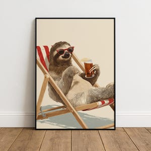May include: A framed art print shows a sloth wearing red sunglasses, relaxing in a deckchair, and holding a pint of beer. The sloth is brown and grey, the chair is wood with red and white stripes, and the beer is amber-coloured.