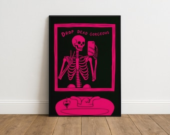 May include: A framed art print featuring a pink skeleton taking a selfie with a phone. The skeleton is inside a pink frame with the words "DROP DEAD GORGEOUS" at the top. The background is black, and the print is displayed on a wall.