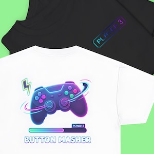 May include: Two t-shirts, one black and one white. The white shirt features a neon-style controller graphic with the text "BUTTON MASHER" and "PLAYER 3". The black shirt has "PLAYER 3" on the sleeve.
