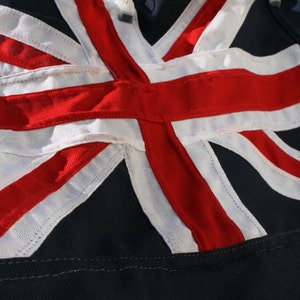 Blauwe vlaggestikte vlag. Stof met MOD-specificatie. Touw en sluiting van canvas