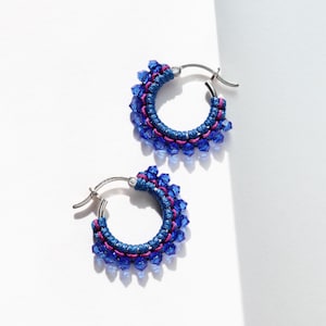 May include: A pair of silver hoop earrings with blue and pink crystal beads.