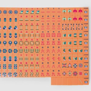May include: A complete set of orange mahjong tiles arranged in a grid. The tiles feature various colorful illustrations, including numbers, Chinese characters, directional symbols, flowers, and joker tiles with crown icons, all on a solid orange background.
