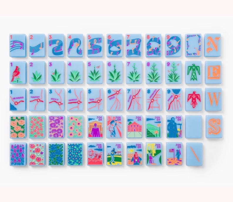 Puede incluir: Un conjunto de fichas de mahjong rectangulares de color azul claro con ilustraciones coloridas que incluyen notas musicales, plantas del desierto, rutas de mapas, patrones florales e iconos culturales. Algunas fichas muestran los n&uacute;meros del uno al nueve, otras las letras N, E, W, S o la palabra JOKER.