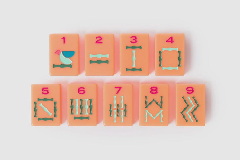 May include: A set of nine rectangular peach-colored mahjong tiles arranged in two rows. Each tile features a pink numeral from one to nine at the top, with various geometric and stylized green and light blue patterns engraved below the numbers.