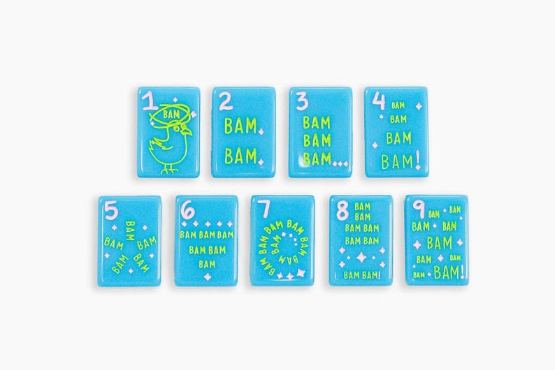 May include: A set of nine rectangular light blue tiles, each featuring a white number from one to nine and the word BAM in various lime green graphic arrangements, including a bird illustration, dots, stars, and exclamation points.