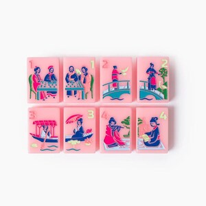 Puede incluir: Ocho fichas de mahjong rectangulares de color rosa dispuestas en dos filas. Cada ficha presenta una ilustraci&oacute;n colorida en relieve de figuras con vestimenta tradicional, incluyendo escenas con barcos, puentes y mesas, con los n&uacute;meros 1, 2, 3 o 4 en verde.
