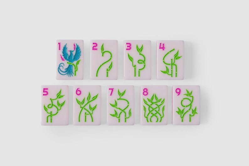 Puede incluir: Un conjunto de nueve fichas de mahjong rectangulares con una base de color lavanda claro. Cada ficha presenta un n&uacute;mero rosa brillante del uno al nueve en la esquina superior izquierda y un dise&ntilde;o gr&aacute;fico de bamb&uacute; verde, con un f&eacute;nix azul en el uno.