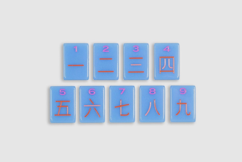 May include: Nine rectangular light blue tiles arranged in two rows. Each tile features a pink Arabic numeral at the top and a corresponding orange Chinese character for numbers one through nine centered below the numeral on the tile surface.