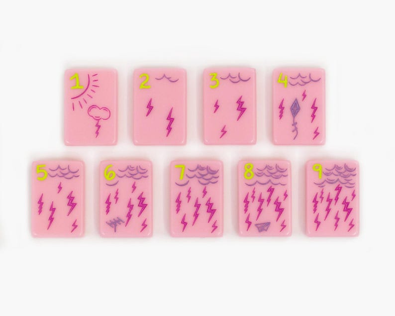 May include: Nine rectangular pink tiles arranged in two rows. Each tile features a lime green number from one to nine and purple line art illustrations of weather patterns, including clouds, sun, lightning bolts, a kite, and a paper airplane.