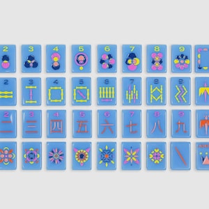 May include: A set of rectangular light blue tiles arranged in a grid, featuring colorful graphic designs, numbers one through nine, and directional labels including North, East, South, and West in yellow, pink, and dark blue ink.