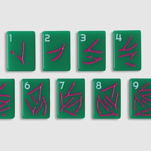 May include: A set of nine rectangular green tiles, each featuring a white numeral from one to nine in the top left corner and a corresponding number of pink wishbone-shaped symbols arranged in the center of each tile surface.