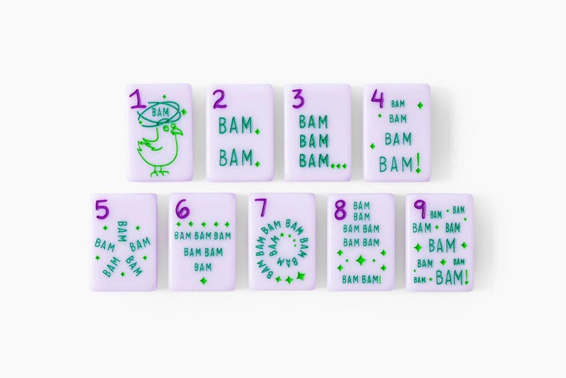 Pu&ograve; includere: Un set di nove tessere rettangolari color viola chiaro disposte su due file. Ogni tessera presenta un numero viola da uno a nove e testo verde con la scritta BAM in varie disposizioni, inclusa un'illustrazione di un uccello.