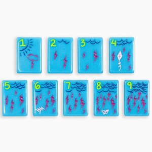 May include: Nine rectangular light blue tiles arranged in two rows, each featuring a bright green number from one to nine. The tiles display weather-themed illustrations including clouds, lightning bolts, a sun, a kite, an antenna, and a paper airplane.
