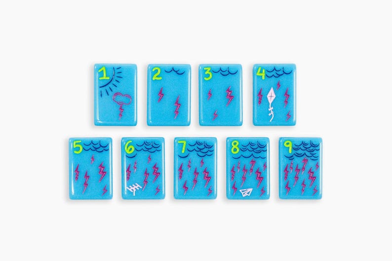 May include: Nine rectangular light blue tiles arranged in two rows, each featuring a bright green number from one to nine. The tiles display weather-themed illustrations including clouds, lightning bolts, a sun, a kite, an antenna, and a paper airplane.