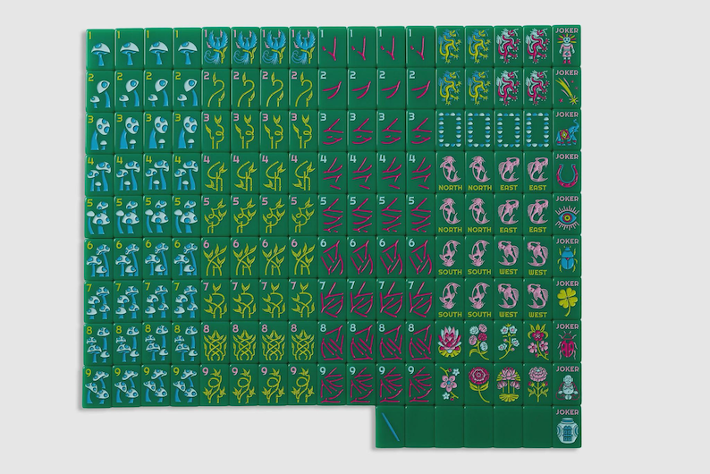 May include: A set of green Mahjong tiles arranged in a grid, featuring various colorful illustrations including mushrooms, plants, dragons, compass directions, and joker tiles with symbols like an elephant, eye, beetle, clover, and a small figure.