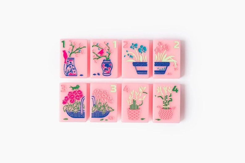 Puede incluir: Ocho baldosas rectangulares de color rosa dispuestas en dos filas, cada una con una ilustraci&oacute;n floral o vegetal &uacute;nica en azul, verde y rosa, con un n&uacute;mero verde correspondiente del uno al cuatro en la esquina superior.