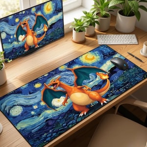May include: A desk setup featuring a computer monitor and a long mousepad, both displaying a vibrant image of a Charizard against a starry night sky, reminiscent of Van Gogh's style. The mousepad is rectangular and has a black mouse on it.