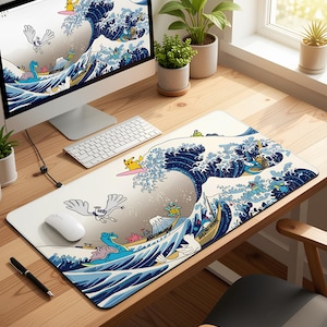 May include: A rectangular desk mat with a Japanese wave design and cartoon characters surfing. The mat has a white background with blue and white waves and colourful characters. A computer, keyboard, and mouse are on the wooden desk, with plants in the background.