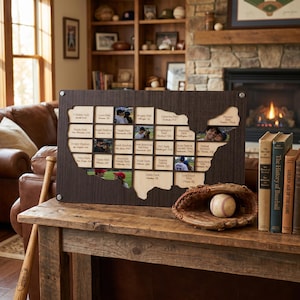 May include: A dark wood map of the United States featuring a grid of slots for baseball stadium photos, labelled with text including MLB STADIUM TOUR and various park names. A leather baseball glove with a white baseball sits in front.