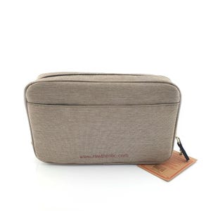 Pu&ograve; includere: Un beauty case rettangolare color beige con chiusura a zip e una piccola tasca frontale. La borsa ha un aspetto strutturato e un'etichetta attaccata con uno spago. L'indirizzo del sito web www.rawthentic.com &egrave; stampato sulla borsa.