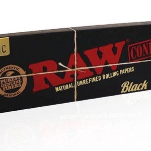 May include: A rectangular black box of RAW Black King Size cones featuring red and gold text. The packaging displays the text CLASSIC, RAW, CONE, 20 CONES PER PACK, NATURAL UNREFINED ROLLING PAPERS, and a circular logo with the words AUTHENTIC PUREST GENUINE FIBERS.