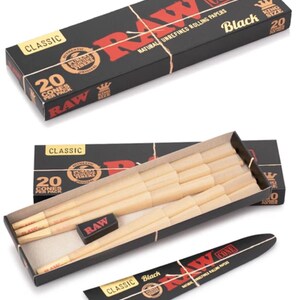 May include: A black rectangular box labeled RAW Classic Black King Size containing 20 pre-rolled paper cones. The open box reveals light tan paper cones arranged in rows, a small black rectangular packing tool, and a separate black paper sleeve.