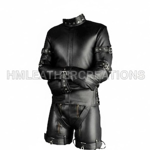 Puede incluir: Conjunto de chaqueta y pantalón corto de cuero negro con múltiples correas, hebillas y cremalleras. La chaqueta tiene un cuello alto con remaches y el pantalón corto tiene tirantes. El texto "HMLEATHERCREATIONS" es visible.