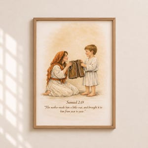 May include: A framed print featuring a watercolor illustration of a mother and child. The mother, kneeling, offers a brown coat to the child. The image includes the text "Samuel 2:19" and a quote about the coat. The artwork is set against a soft, neutral background.