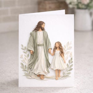 May include: A white greeting card featuring a 3D paper art depiction of a figure in a long robe holding hands with a young girl in a white dress. The figures are surrounded by green and white foliage.