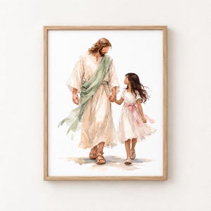 Op de afbeelding: Een ingelijste aquarelprint met een langharige figuur in een crèmekleurig gewaad met een saliegroene sjerp die naast een jong kind in een witte jurk met een roze lint loopt, beiden dragen sandalen op een lichtgekleurde ondergrond.