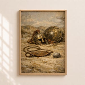 Op de afbeelding: Een ingelijste prent van een klassiek schilderij met oude Romeinse of Griekse militaire artefacten. Het kunstwerk toont een gouden helm, schild en andere voorwerpen op een zanderige grond, met een gedempt kleurenpalet en een landschapsachtergrond.