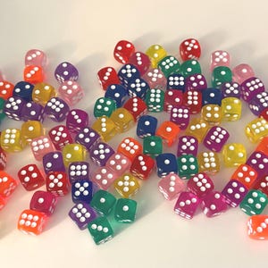 May include: A large collection of six-sided dice in various translucent colors including red, orange, yellow, green, blue, purple, and pink. Each die features rounded corners and white pips representing numbers one through six on each face.