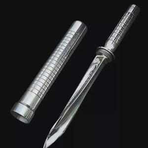 May include: A polished silver dagger with a matching sheath. The dagger features a textured handle and a sharp, curved blade. The sheath is cylindrical with a similar textured pattern.