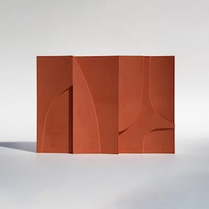 Può includere: Una scultura da parete astratta color terracotta con un design geometrico. La scultura è composta da diversi pannelli rettangolari con ritagli curvi e lineari, creando un effetto a strati. Il pezzo è ambientato su uno sfondo bianco.