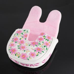 May include: A mallet-style putter headcover featuring a white base with a pink floral pattern and green stems. The interior is lined with soft light pink fabric. The side of the headcover displays the text "GAME OVER" in pink lettering.