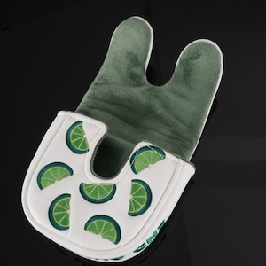 Pu&ograve; includere: Un copri-putter bianco con un motivo ripetuto di fette di lime verdi. L'esterno &egrave; bianco con una finitura liscia, mentre l'interno &egrave; foderato con un morbido tessuto felpato verde scuro. Il copri-putter presenta un caratteristico design a U.