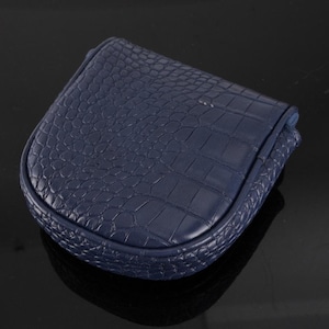 May include: A small, navy blue coin purse with a rounded, U-shaped silhouette. The exterior features a textured, embossed crocodile skin pattern across the entire surface, including the curved edges and the top flap closure.