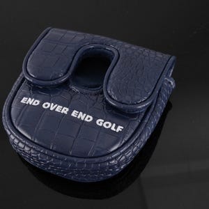 May include: A navy blue golf putter headcover featuring a textured crocodile skin pattern. The cover has a U-shaped cutout at the top and the white text "END OVER END GOLF" printed across the front surface of the rounded, structured accessory.