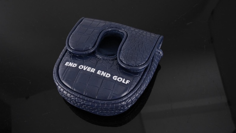 May include: A navy blue golf putter headcover featuring a textured crocodile skin pattern. The cover has a U-shaped cutout at the top and the white text "END OVER END GOLF" printed across the front surface of the rounded, structured accessory.