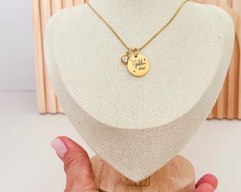 以下が含まれることがあります： 「Golden soul」と書かれたペンダントが付いたゴールドカラーのネックレス。ネックレスには、小さく透明な丸いチャームも付いています。ネックレスはマネキンのバストに飾られています。