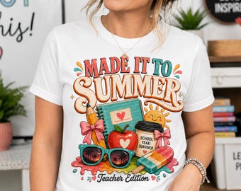 May include: White t-shirt with a colorful graphic that reads "MADE IT TO SUMMER" with school-themed illustrations. The design includes a pencil, notebook, apple, sunglasses, coffee cup, and popsicle. "Teacher Edition" is also printed on the shirt.