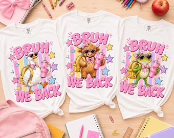 May include: Three white t-shirts featuring graphic prints of a duck, a highland cow, and a frog. Each character wears heart-shaped sunglasses, a bow tie, and carries a backpack and a pink tumbler. The text BRUH WE BACK is printed in pink.