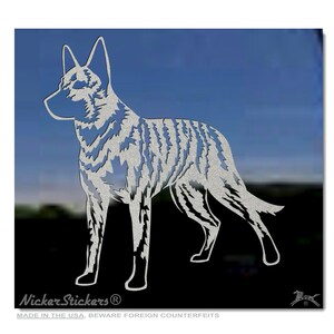 May include: A silver vinyl decal of a standing dog silhouette. The dog is a breed known as a  "Carolina Dog" and is a type of wild dog. The decal is made in the USA and has the text "Nicker Stickers" on the bottom.