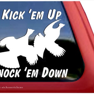 Könnte beinhalten: Weißer Vinyl-Aufkleber mit dem Text "Kick 'em Up" und "Knock 'em Down" mit einer Silhouette von zwei Auerhähnen.
