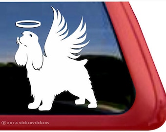 Könnte beinhalten: Weiße Silhouette eines Cocker Spaniels mit Engelsflügeln und einem Heiligenschein über seinem Kopf. Der Hund schaut nach oben und hat den Mund leicht geöffnet. Das Bild ist auf schwarzem Hintergrund.