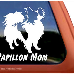 May include: White silhouette of two Papillon dogs on a black background with the text "Papillon Mom" below.