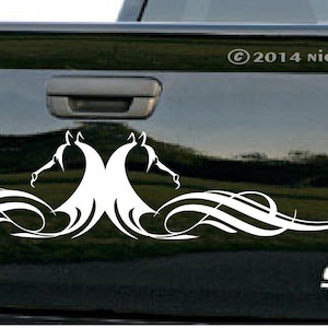 Puede incluir: Calcoman&iacute;a de vinilo blanco de dos cabezas de caballo estilizadas con l&iacute;neas fluidas, aplicada a la puerta trasera de una camioneta negra. La camioneta tiene los emblemas "COLORADO" y "SS".