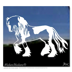 Pode incluir: Autocolante de vinil branco de um cavalo em pose de andar. O cavalo tem uma crina e cauda fluídas, com detalhes nas pernas e cascos. O autocolante está sobre um fundo azul e preto. O texto "Nicker Stickers" é visível.