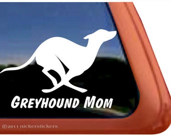 May include: White silhouette of a greyhound running with the text "Greyhound Mom" below it. The decal is on a car window.