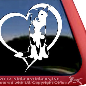 Könnte beinhalten: Weißer Vinyl-Aufkleber mit der Silhouette eines Border Collie-Hundes in einem Herzen. Der Hund schaut nach oben und hat einen fröhlichen Ausdruck. Der Aufkleber ist perfekt für Autofenster, Laptops oder Wasserflaschen.